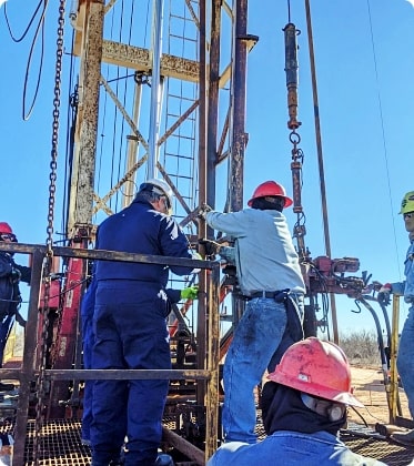 Oil rig technicians deploying HAI oil recovery tool in upstream oil production environment